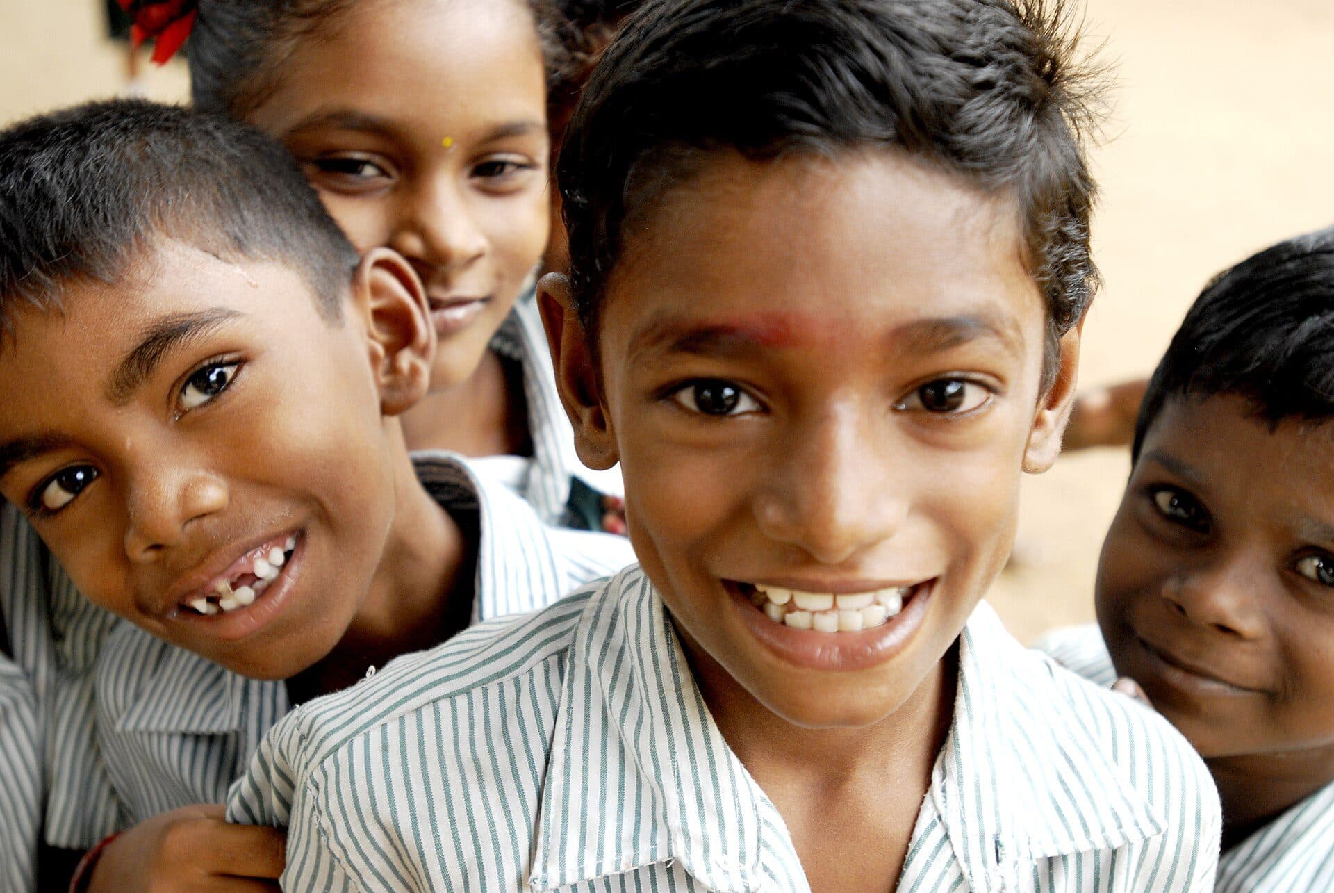 Boys in school uniform grinning at the camera