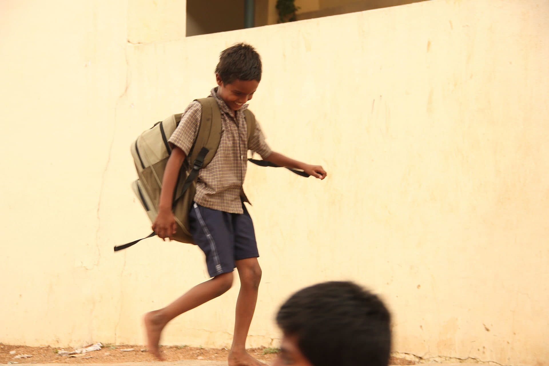 A schoolboy with a backpack stepping forward
