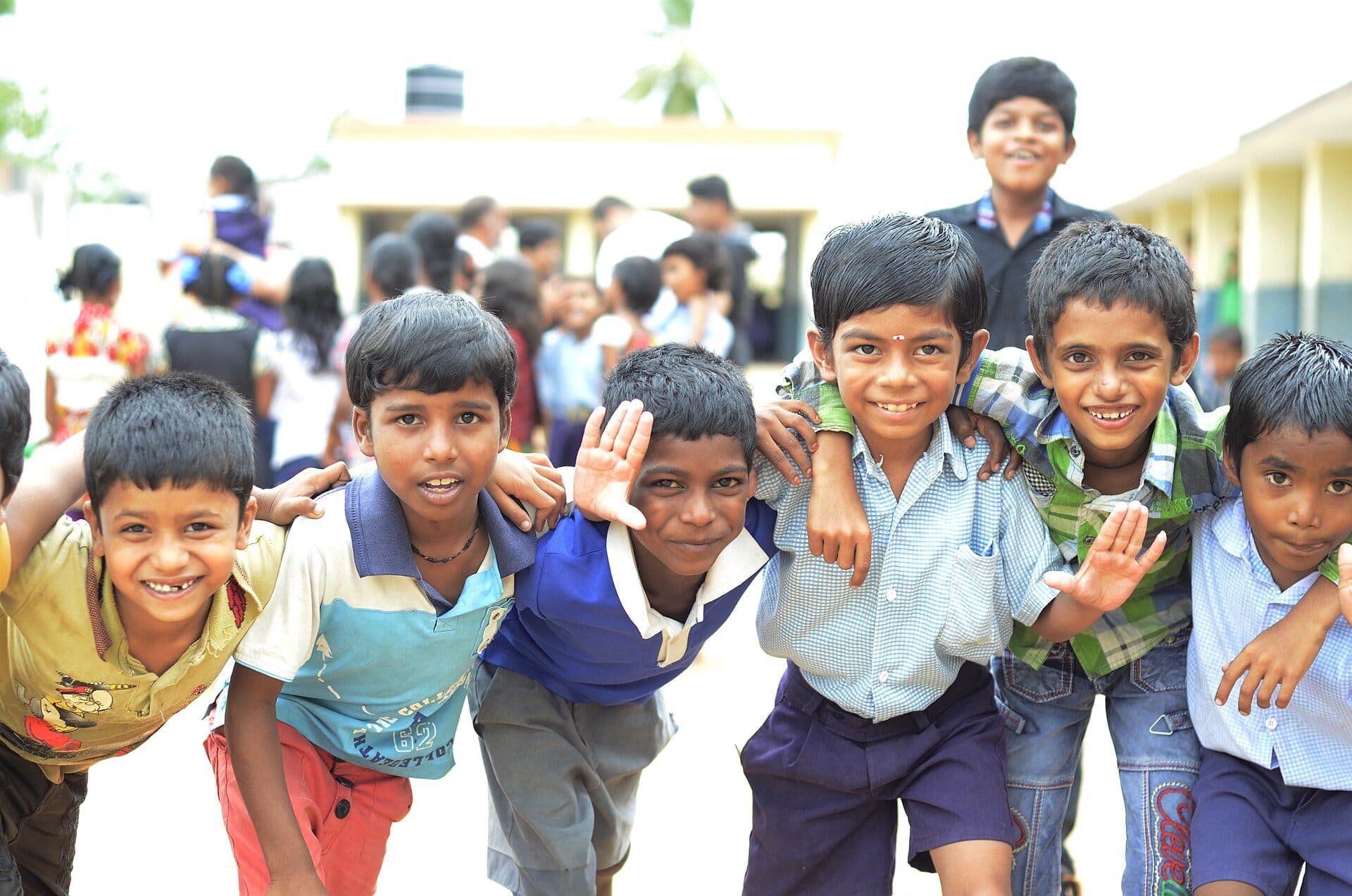 Smiling schoolchildren in uniform crowding together for a photo